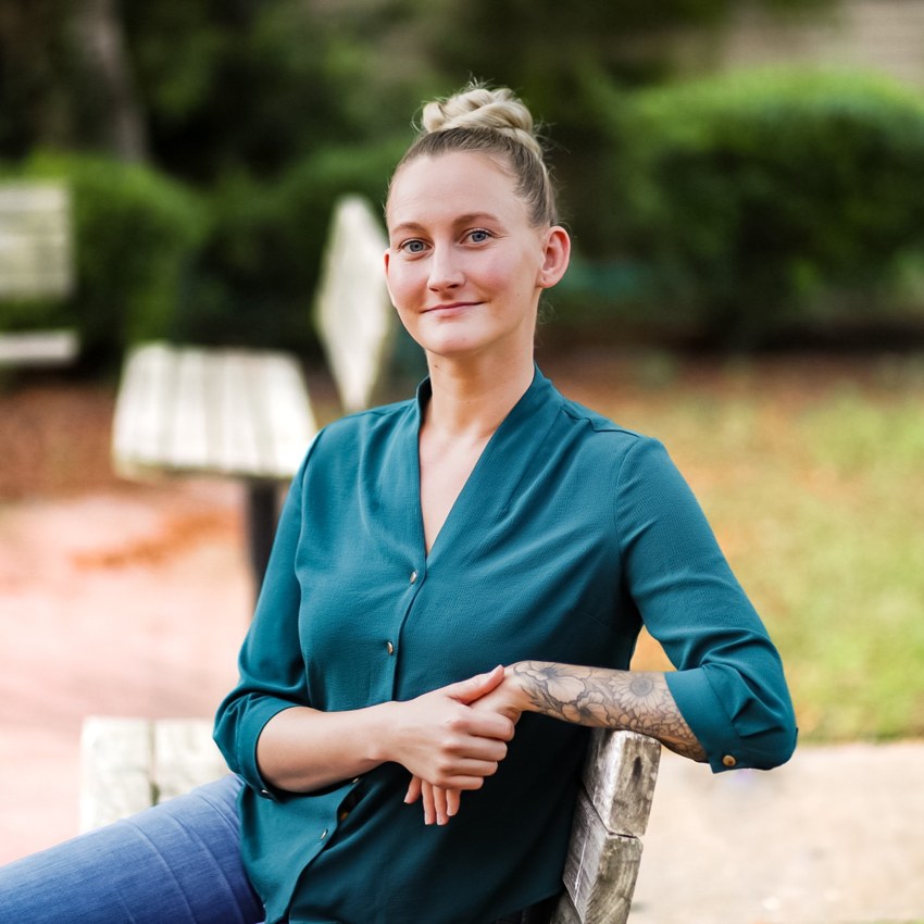 Heather Stewart sitting outside on a wooden chair